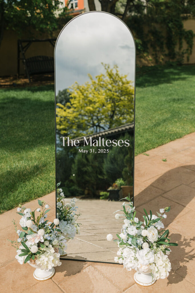 Mirrored wedding welcome sign with florals at Colorado wedding reception.