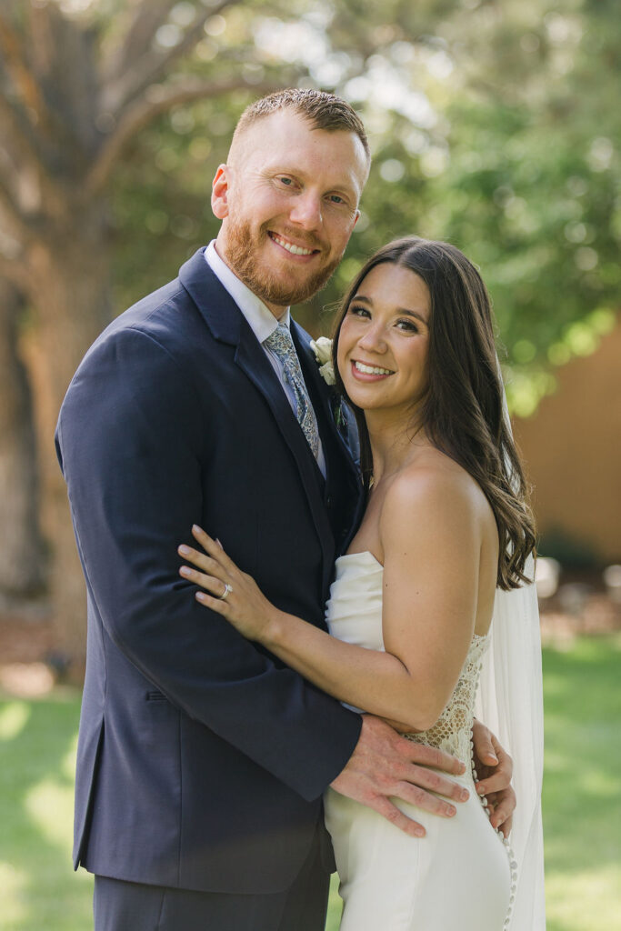 Bride and groom smiling during classic Colorado wedding portraits.