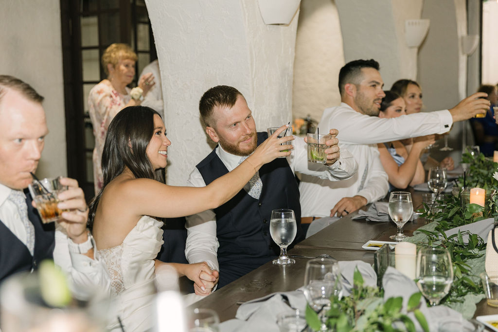 Bride and guests raising their glaases during Colorado wedding toast.