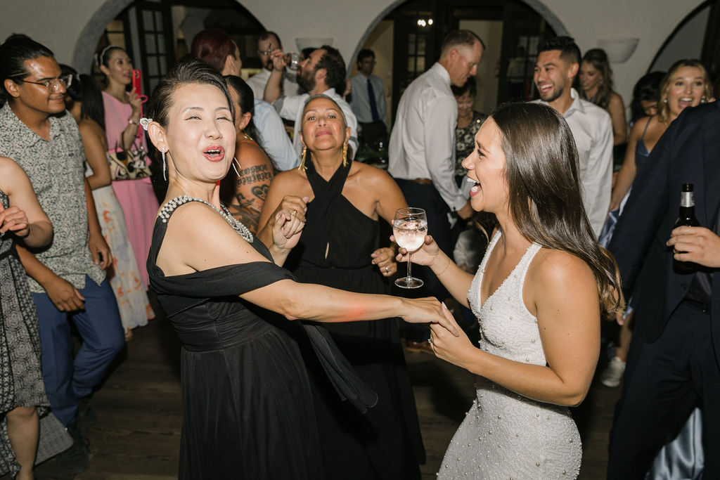 Bride laughing and dancing with her mom during her Villa Parker wedding reception.