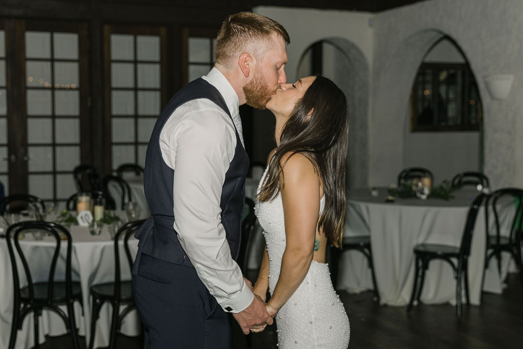 Groom kissing bride during late-night celebration at Villa Parker.