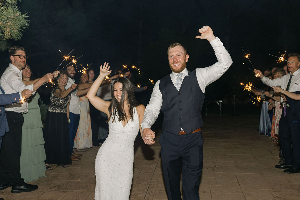 Bride and groom walking through sparkler exit tunnel at Colorado wedding.