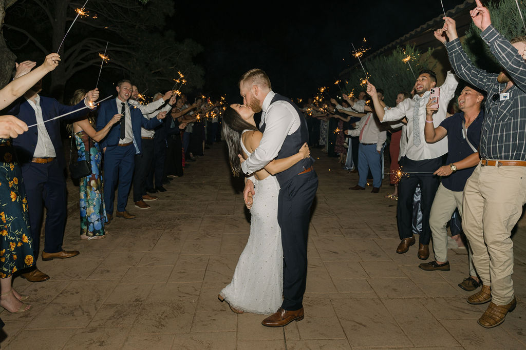 Bride and groom sharing final kiss under sparklers at Villa Parker wedding.
