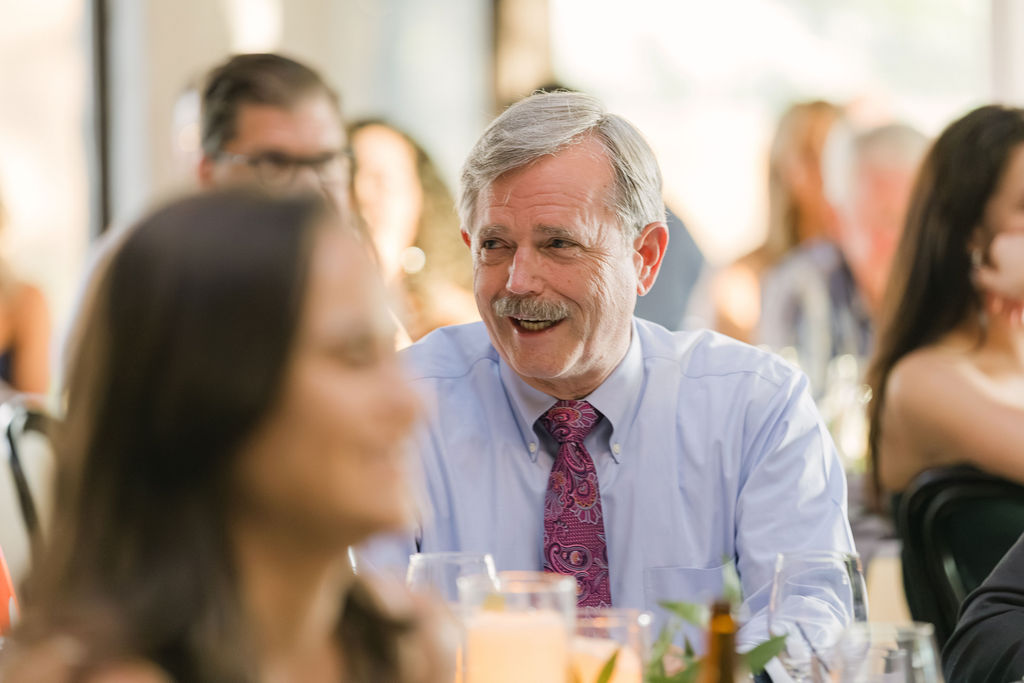 Candid photo of guest smiling during dinner at Colorado wedding reception.
