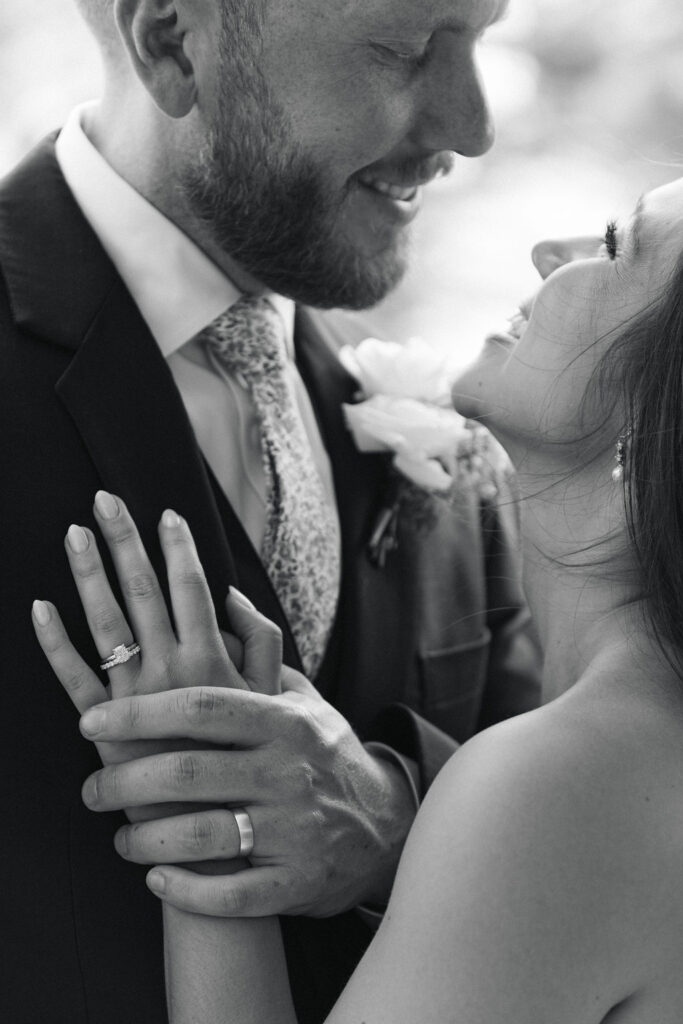 Black and white close-up ring shot of bride and groom smiling together during their Villa Parker wedding portraits
