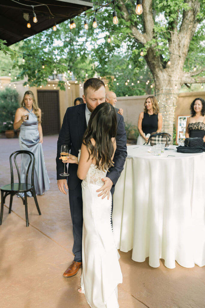 Bride hugging groom during cocktail hour at Colorado garden wedding.