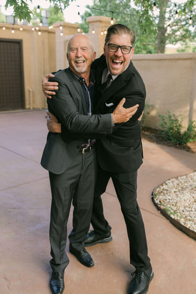 Guests hugging and laughing at outdoor Colorado wedding celebration.