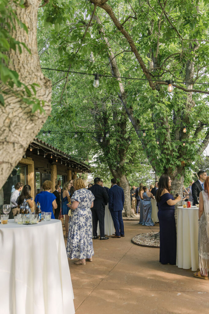 Guests mingling under string lights in the courtyard at Colorado wedding venue.