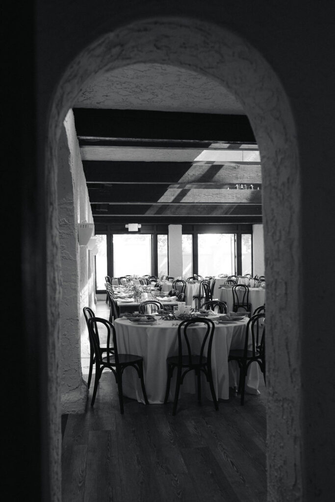 Black-and-white view of Villa Parker reception room through arched doorway.