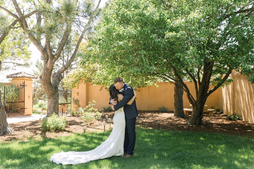 Bride and groom sharing first look kiss in the backyard lawn at Villa Parker.