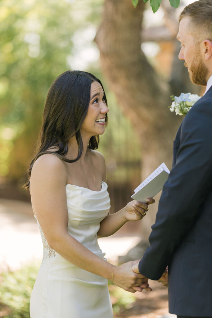 Bride reading vows to groom during intimate Colorado garden ceremony.