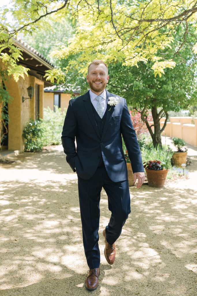 Groom walking down a garden path at Villa Parker, featuring the venue’s European-inspired architecture during this Colorado wedding.