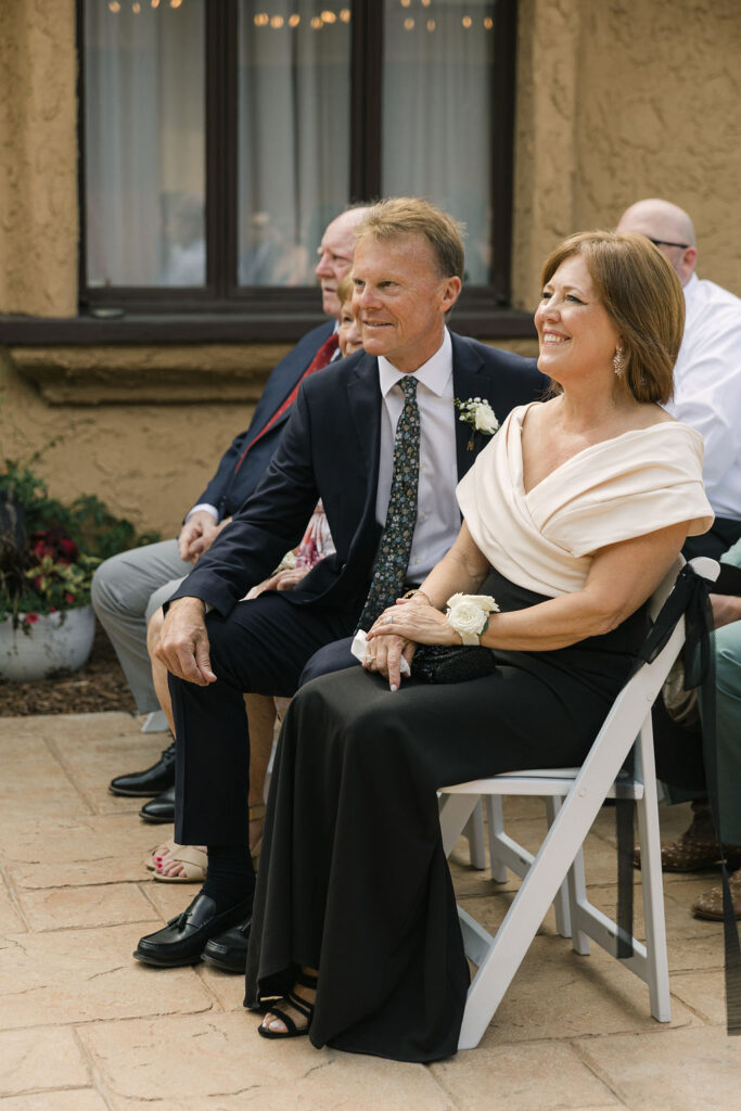 Parents of the groom seated at the Villa Parker ceremony during this Colorado garden-style wedding.
