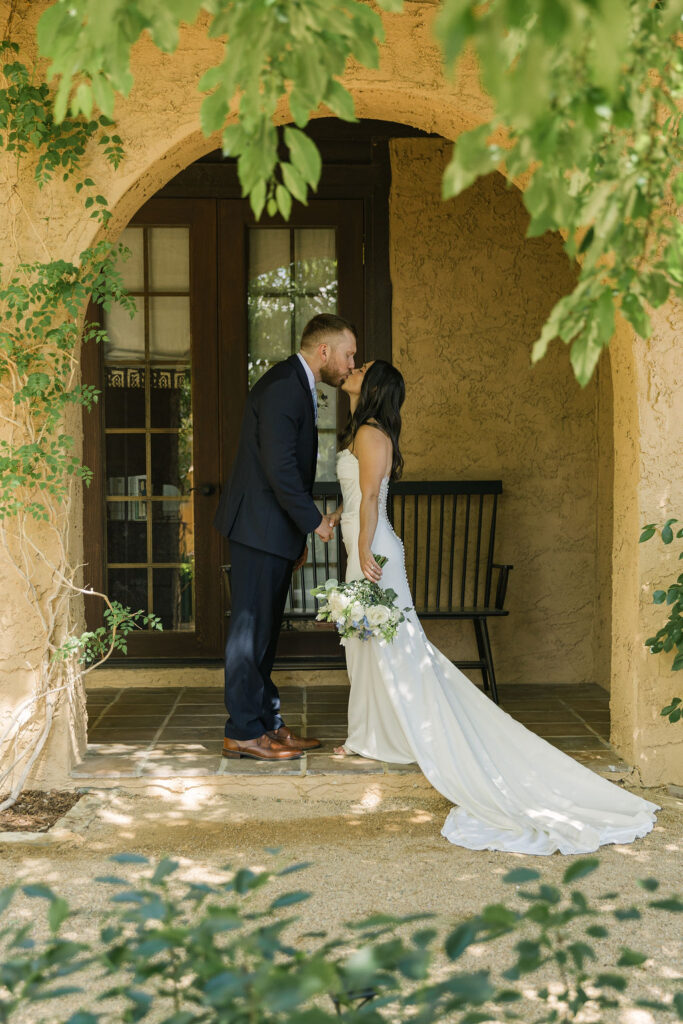 Couple sharing a kiss under archway at European-inspired Villa Parker.