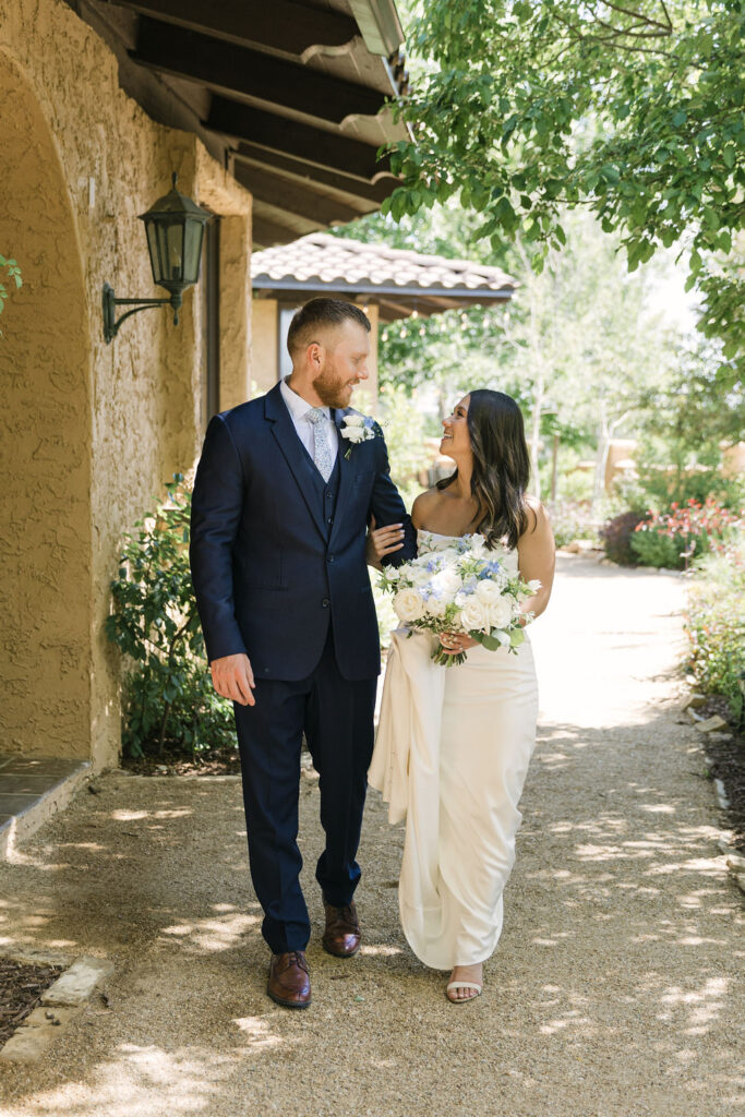 Bride and groom walking garden path surrounded by greenery at Villa Parker.