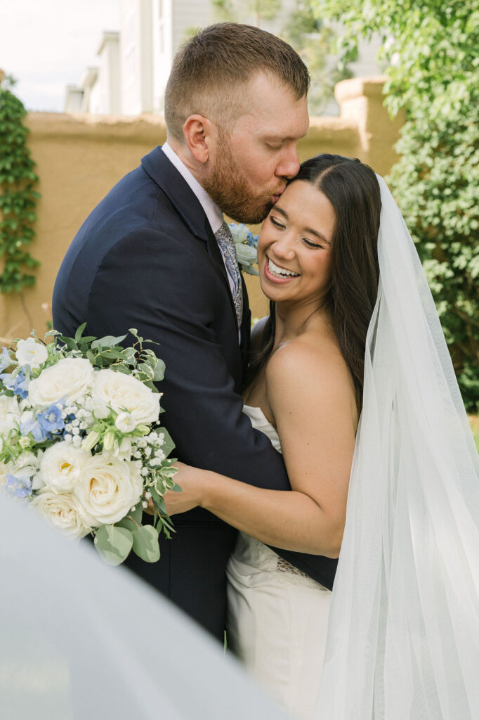 Groom holding bride close during portraits at Colorado wedding venue.