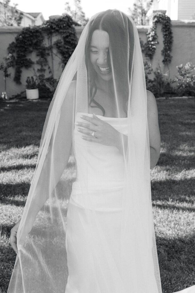 Bride standing alone with her veil draped around her face, photographed in soft, editorial style at Villa Parker in Colorado.