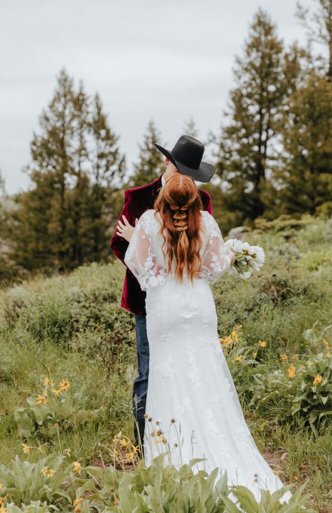 Bride and groom kissing in the wildflowers at The Wedding Tree
