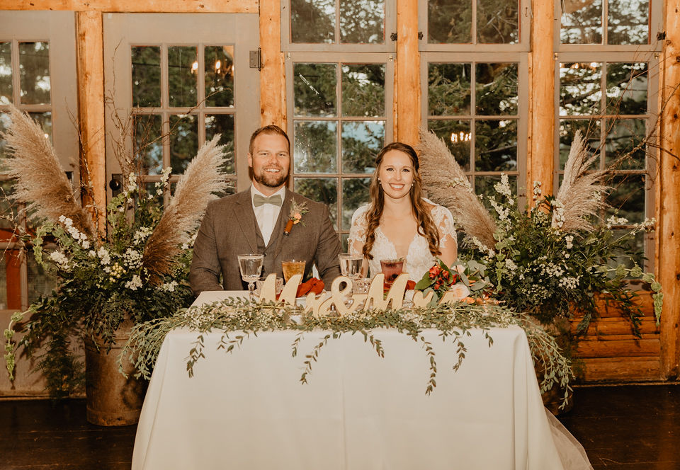 bride and groom at their wedding reception table 