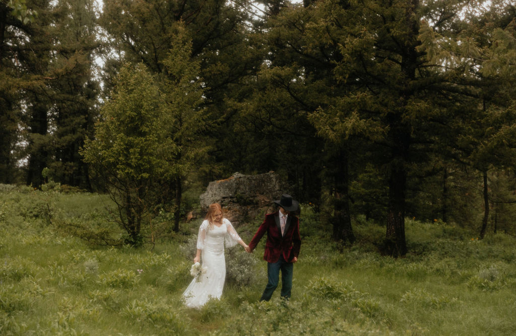 bride and groom walking through a lush field in jackson hole