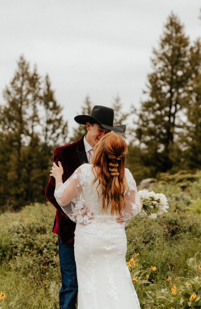 romantic and intimate bride and groom standing in a lush wildflower field