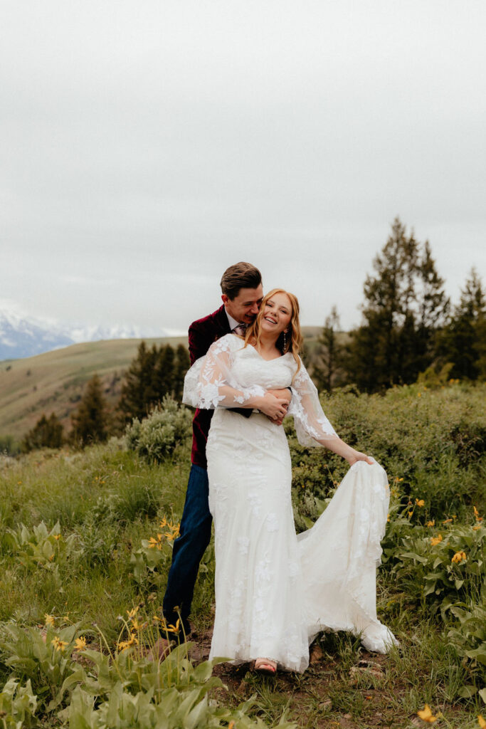 romantic and intimate bride and groom standing in a lush wildflower field