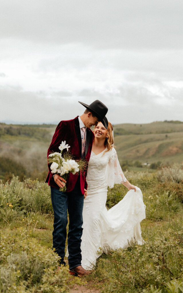 bride and groom walking through a lush wildflower field in jackson hole