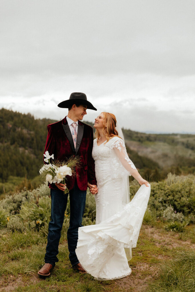 bride and groom walking through a lush wildflower field in jackson hole