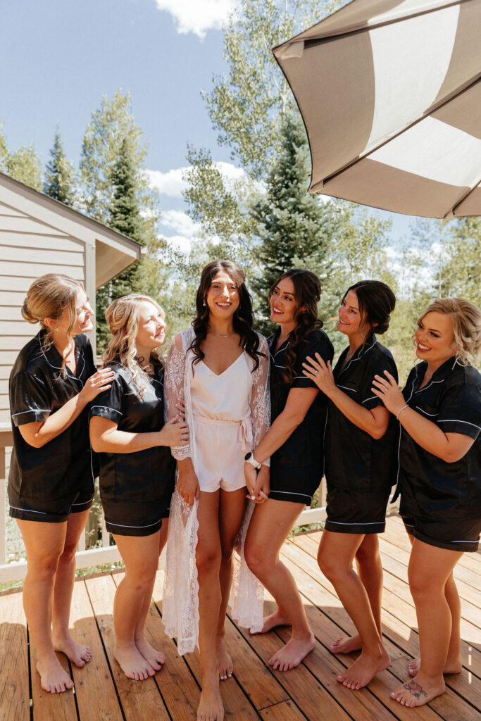 bride and bridesmaids in silk pjs as they are getting ready for the day