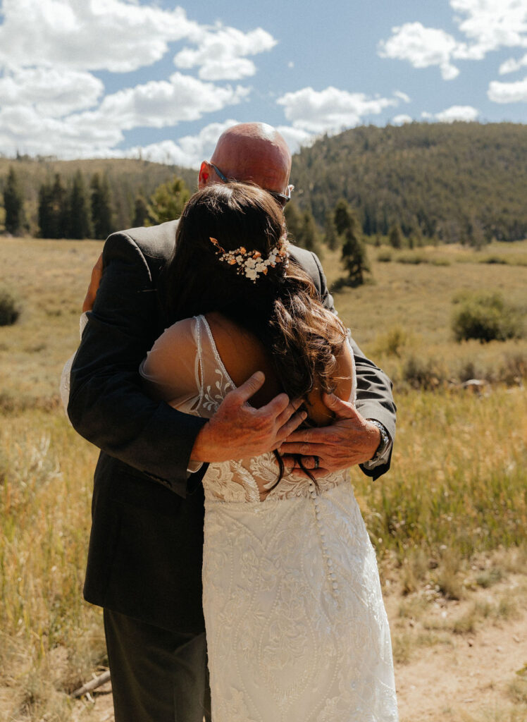 bride and dad first look in a vast open meadow