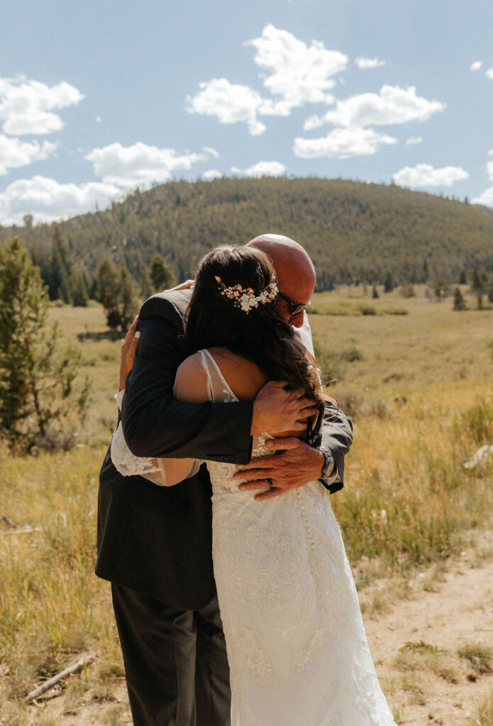 bride and dad first look in a vast open meadow