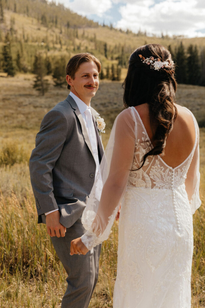 bride and groom first look in a vast open meadow