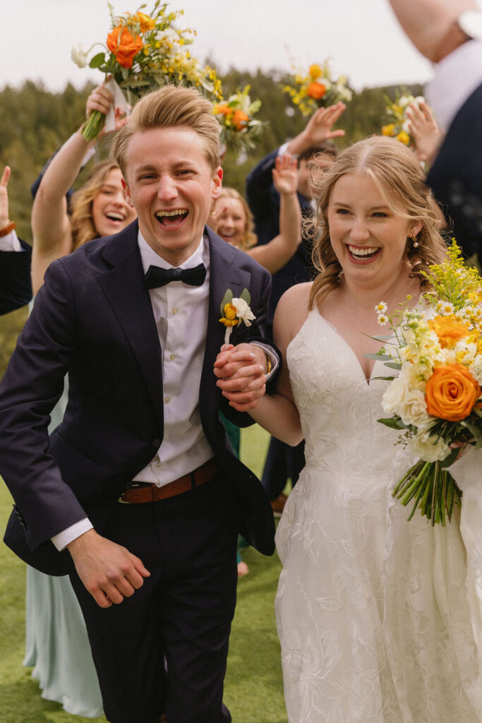 bride and groom running through a hand tunnel