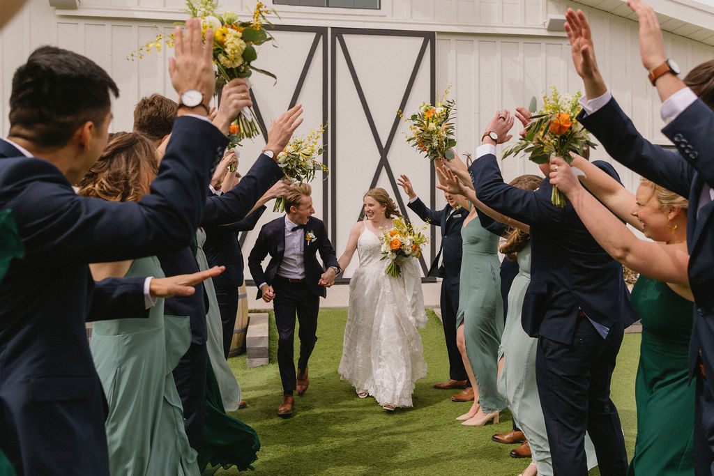 bride and groom running through a hand tunnel