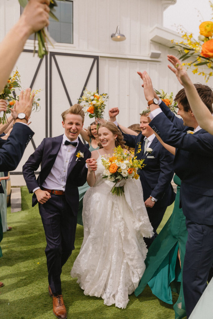 bride and groom running through a hand tunnel