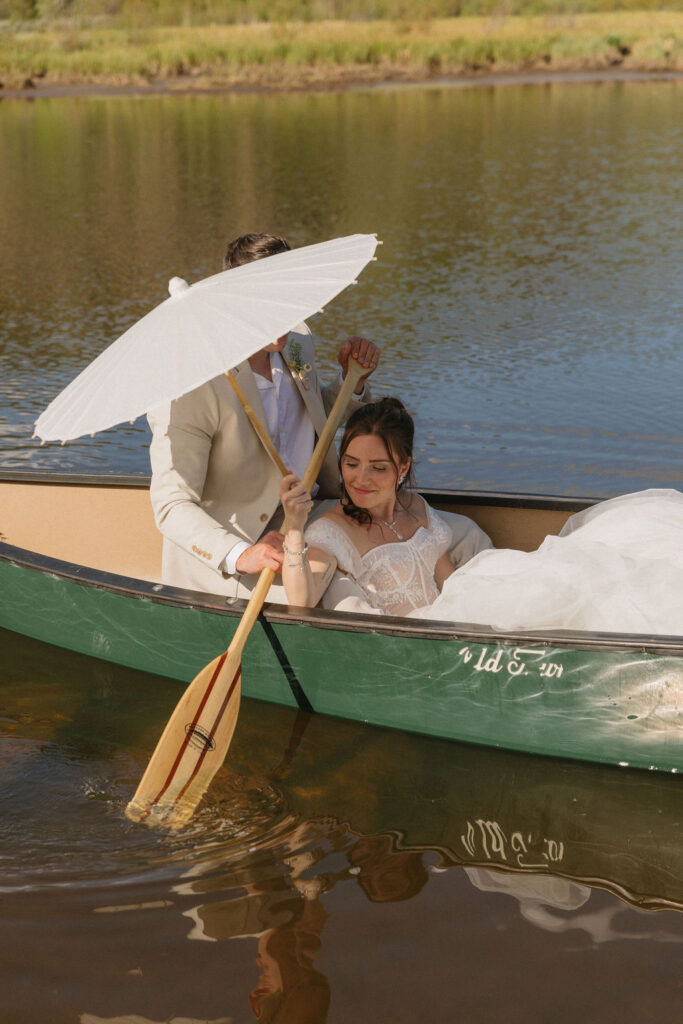 romantic bride and groom in a row boat together in camp hale