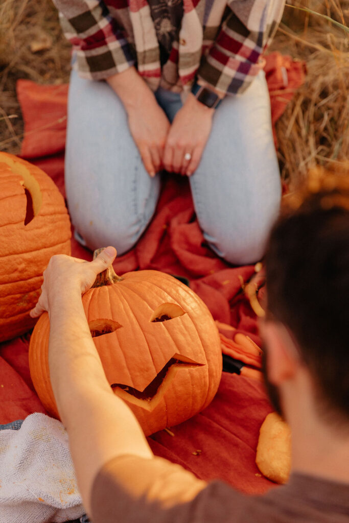 Unique fall engagement session carving pumpkins in Fort Collins outdoors