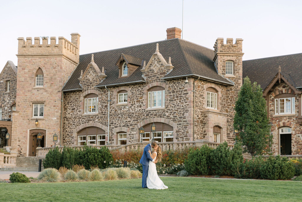 bride and groom kissing in front of their Highlands Ranch Mansion wedding venue