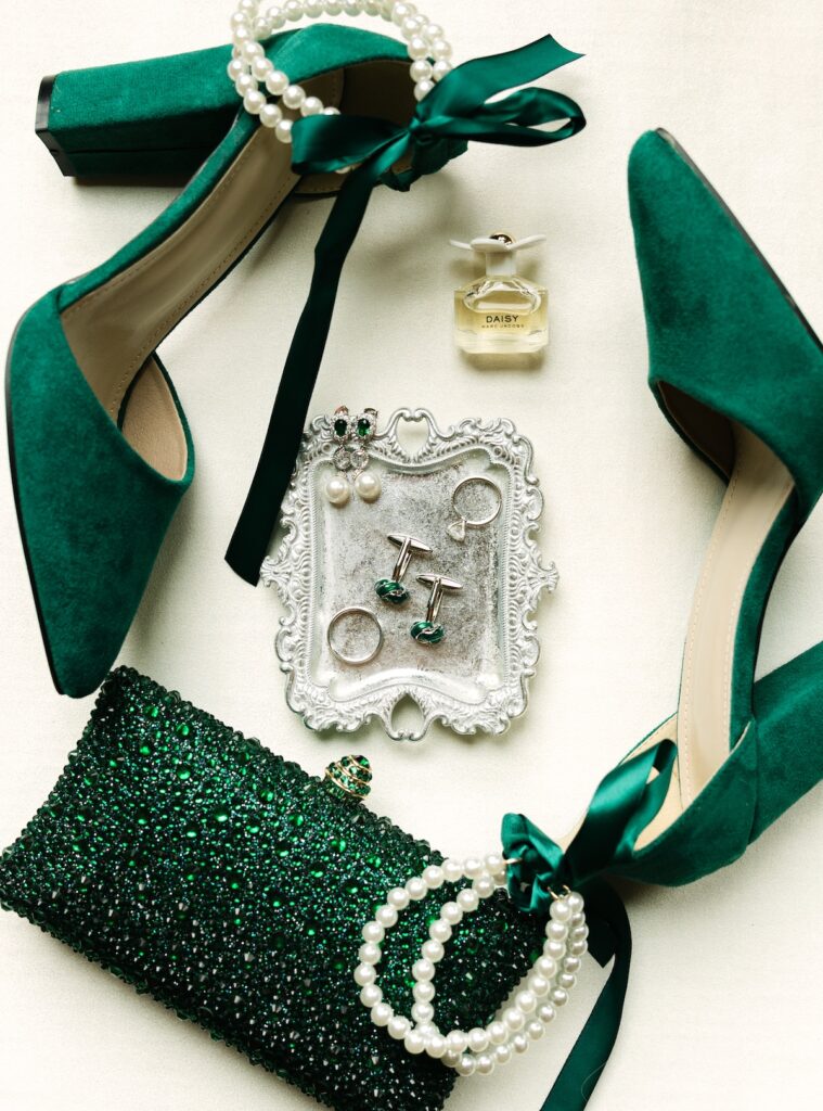 Elegant emerald green wedding details styled on a luxury mat at Della Terra Mountain Chateau. 