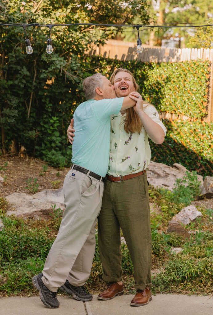 Groom and his dad sharing a candid, funny moment during a summer outdoor mountain wedding in Boulder, Colorado.