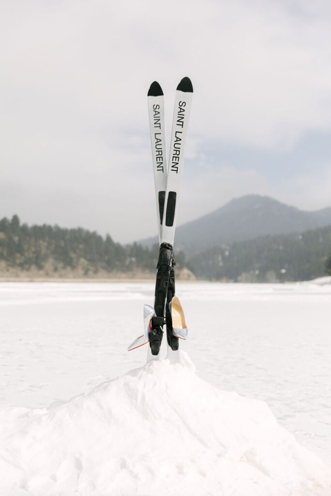 Chrome christian louboutins hanging on a pair of Saint Laurent skis on Evergreen Lake at a Colorado luxury wedding. 