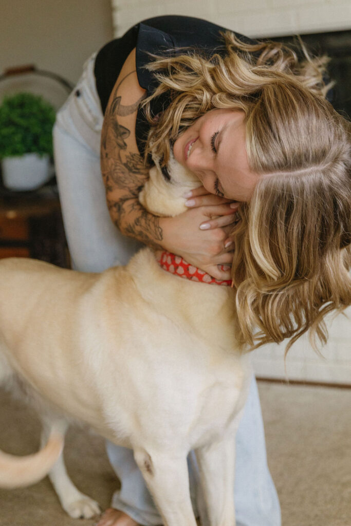 Intimate moment hugging her dog during their indoor engagement photos with dogs. 