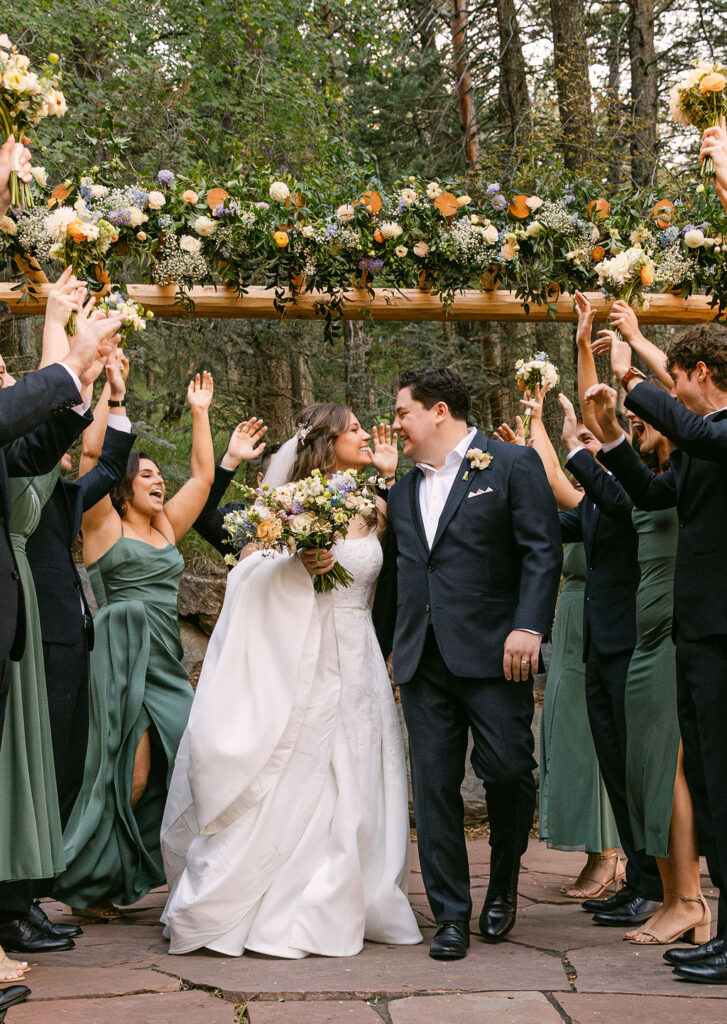 happy bride and groom surrounded by their excited cheerful wedding party