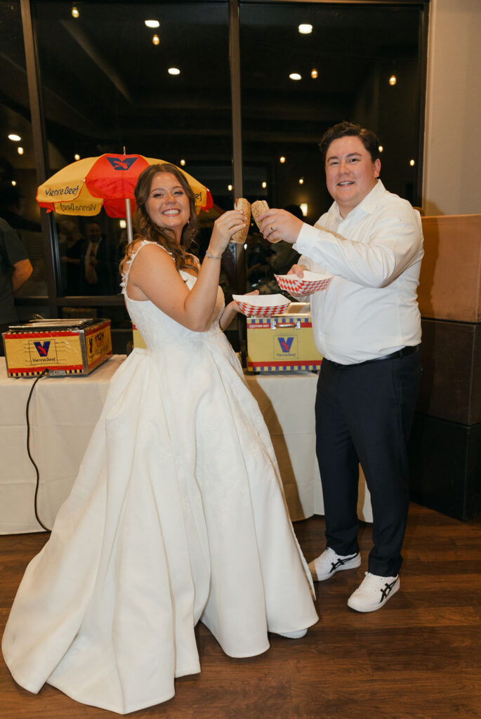 bride and groom enjoying hot dogs during their wedding