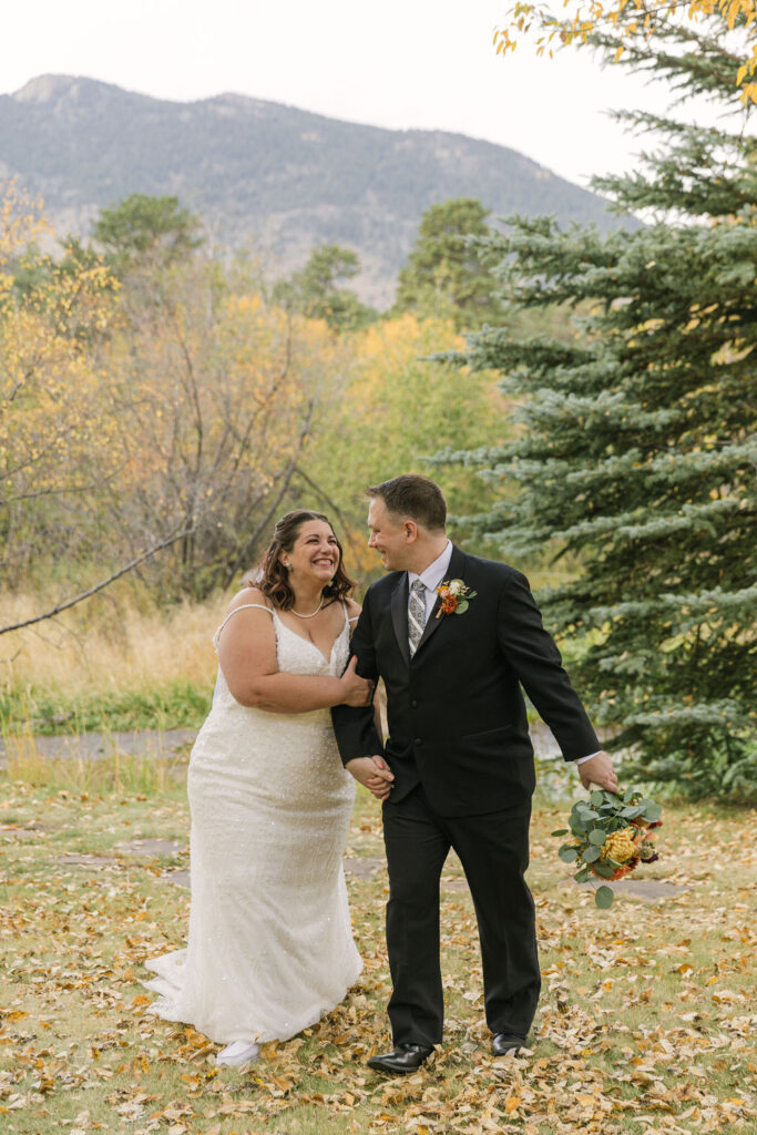 playful bride and groom exploring estes park during their elopement at the romantic riversong inn