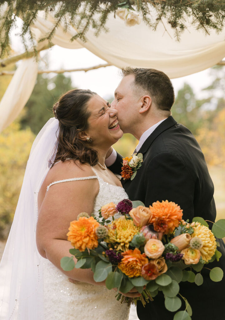 groom kissing bride on the cheek