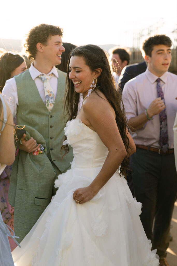 Bride and groom laughing together at Colorado wedding reception during golden hour celebration