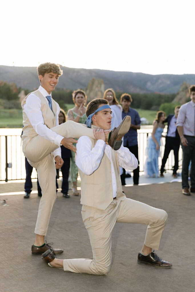 Groomsmen and wedding party having fun with playful antics at Perry Park Country Club mountain wedding reception