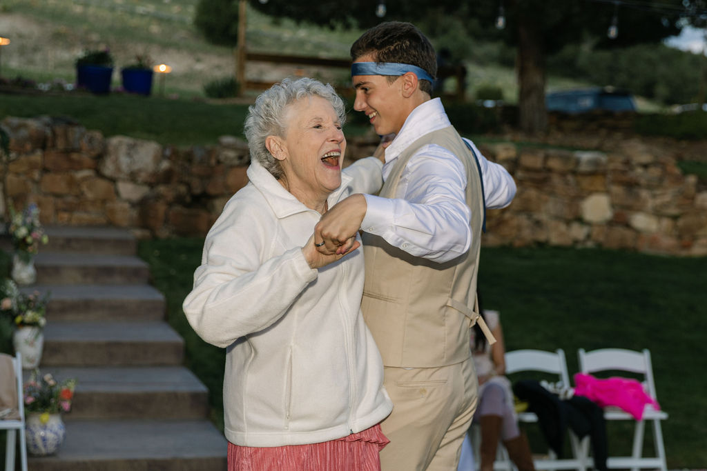 Grandmother and groomsmen laughing while dancing at a Perry Park wedding reception