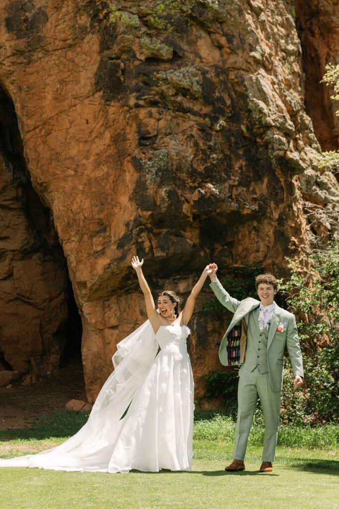 Perry Park Country Club wedding photos featuring bride and groom celebrating against dramatic red rock formations